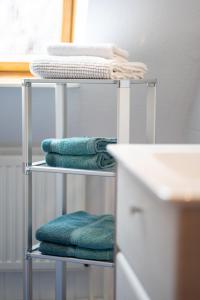 - une pile de serviettes sur un porte-serviettes dans la salle de bains dans l'établissement Fewo Obsthof Matthies, à Jork