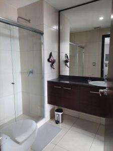 y baño con ducha, aseo y lavamanos. en CORAL SUITE CON VISTA CIUDAD/PISCINA, GYM, PARQUEO, en Guayaquil