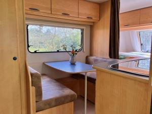 eine kleine Küche mit einem Tisch und einem Fenster in der Unterkunft De kastanjehof 31 in Beerta