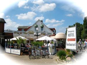 a market with bikes and umbrellas in front of a building at Hotel & Restaurant Möwchen in Norden