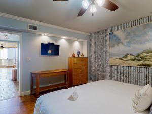 a bedroom with a bed and a dresser and a tv at MP217 Gulf view condo with Boardwalk to Beach in Padre Island