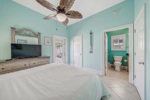 a bedroom with a bed and a ceiling fan at Deja Blue by Sand Seeker Vacations in Panama City Beach +29 photos