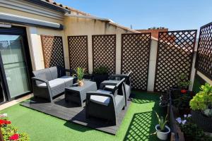 a patio with chairs and tables and a fence at Benicassim SunHouse - Hermoso ático en el Pueblo - Aire acondicionado y BBQ area in Benicàssim