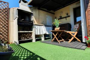 un patio con una mesa y una parrilla con césped en Benicassim SunHouse - Hermoso ático en el Pueblo - Aire acondicionado y BBQ area, en Benicàssim