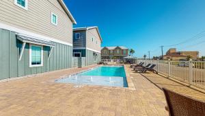 - une piscine en face d'une maison dans l'établissement WPV Beautiful Townhome on Mustang Island, Shared Pool and Close to Beach and Restaurants, à Île Padre