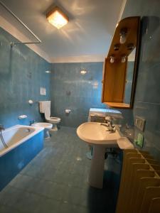 a bathroom with two toilets and a sink and a tub at Appartamento Dona Comano Terme in Ponte Arche