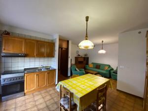 a kitchen with a table and a living room at Appartamento Dona Comano Terme in Ponte Arche