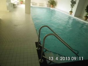 a swimming pool with a metal hand rail in a building at Fewo Cuxhaven/Nordsee in Cuxhaven