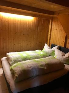a bed with green and white sheets and pillows at Fewo Cuxhaven/Nordsee in Cuxhaven