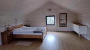 um quarto com uma cama grande num quarto branco em Domek Letniskowy ZŁOTY KARAŚ em Widna Góra