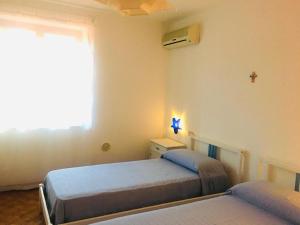 a bedroom with two beds and a window at La Villa di Nino in Ustica