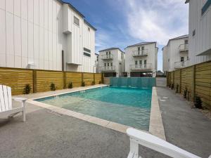 a swimming pool in front of some buildings at Dorado Dunes #D Newly Built, Gorgeous Beach Home, Private Pool, Golf Cart Entire Stay in Port Aransas