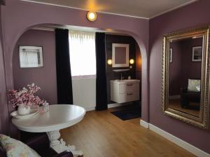 a purple room with a mirror and a table at CITY HOUSE Adults Only in Middelburg