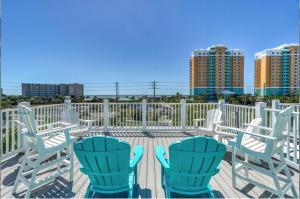 three blue chairs and a table on a deck at Deja Blue by Sand Seeker Vacations in Panama City Beach