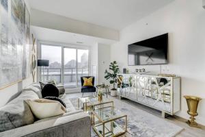 a living room with a couch and a tv at Waterfront Luxury Condo in Toronto