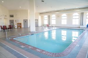 a large swimming pool in a large room with chairs at Quality Inn Seymour I-65 in Seymour