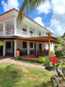 a white house with a porch and patio at Pousada Sunshine Patacho - Praia do Patacho - Rota Ecológica dos Milagres, Porto de Pedras in Pôrto de Pedras