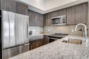 una cucina con frigorifero in acciaio inossidabile e lavandino di Waterfront Luxury Condo a Toronto