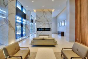 a lobby with two chairs and a table in a building at Waterfront Luxury Condo in Toronto