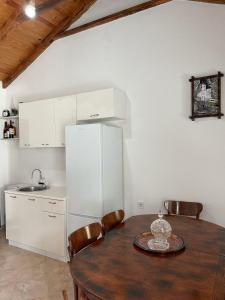 a kitchen with a table and a white refrigerator at Lakeview Apartments Jolicic in Virpazar