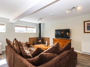a living room with a couch and a fireplace at Orchard Retreat in Paddock Wood