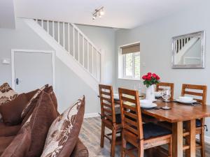 a dining room with a table and a couch at Orchard Retreat in Paddock Wood