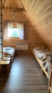 1 dormitorio con 2 camas en una cabaña de madera en Domki na wzgórzu en Ciche Małe