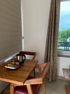 una mesa de madera con una taza de café encima en Kaashi Flora (Full Villa - 5 Bedrooms), en Varanasi