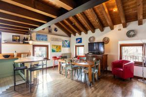 una sala de estar con techos de madera, mesas y sillas en Via Calcada Apartment, en Vittorio Veneto