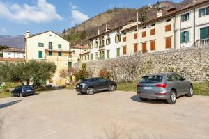 tres autos estacionados en un estacionamiento frente a un edificio en Via Calcada Apartment, en Vittorio Veneto