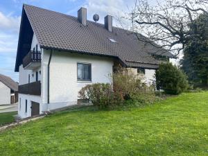 a white house with a black roof and a yard at Ferienhaus Heimberg - Fischach in Fischach