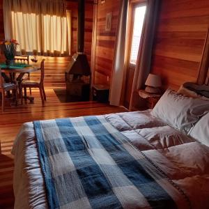 a bedroom with a bed and a table in a room at Pousada Cabanas Xokleng in Urubici