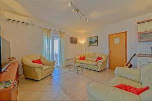 a living room with two couches and a tv at Apartmani Vila Nela in Postira
