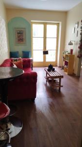 ein Wohnzimmer mit einem roten Sofa und einem Tisch in der Unterkunft Bohemian Santiago in Santiago
