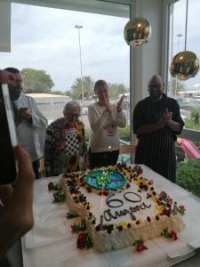 a group of people standing around a birthday cake at Hotel Tritone in Senigallia