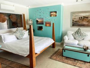 a bedroom with a bunk bed and a couch at Residence William French in Simonʼs Town