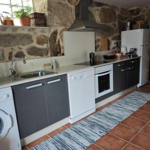 a kitchen with a sink and a stove top oven at Casa Ribadil in Crecíente