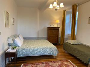 - une chambre avec un lit et une commode dans l'établissement Le Clos Saint Guilhem, à Gerzat