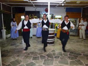 a group of men in traditional dances in a room at XeniCamp & Bungalows in Tolo