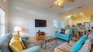 sala de estar con sofás azules y TV en FD115 Spacious Home in Royal Sands, Shared Pool & Hot Tub, Golf Cart Included, Beach Boardwalk en Port Aransas