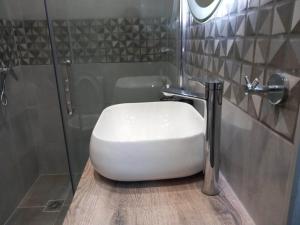 a white toilet in a bathroom with a shower at Nisos suite in Ermoupoli