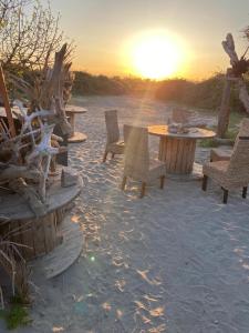 a group of tables and chairs on the beach at sunset at guinguette pour faire la fête in Saint-Laurent-dʼAigouze