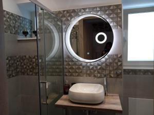 a bathroom with a sink and a mirror at Nisos suite in Ermoupoli