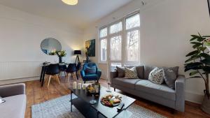 un soggiorno con divano e tavolo di Samdel Dulwich Grove 3 Bed Apartment a Londra