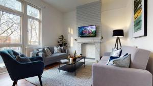 un soggiorno con 2 divani e un camino di Samdel Dulwich Grove 3 Bed Apartment a Londra