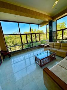 a living room with a couch and a glass table at Kaashi Flora (Full Villa - 5 Bedrooms) in Varanasi