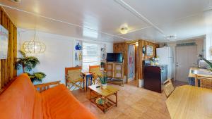 un soggiorno con divano arancione e una cucina di NS731 Coastal Cottage, In Town Near Shops, Restaurants and Nightlife a Port Aransas