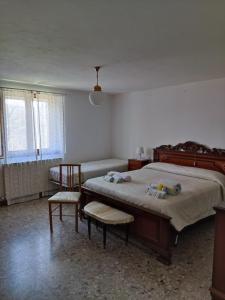 1 dormitorio con 1 cama grande y 2 sillas en BeB Le Masere, en Castel dellʼAlpi