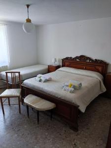 1 dormitorio con 2 camas y 2 sillas en BeB Le Masere, en Castel dellʼAlpi