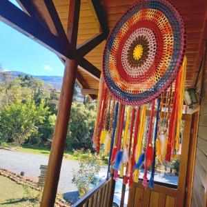 a view from the front door of a house with a hanging decoration at Pousada Cabanas Xokleng in Urubici